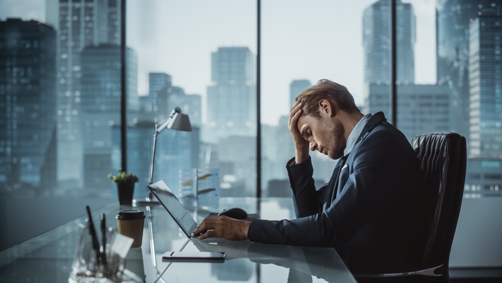 Imageofastressedbusinessmanathisdesk