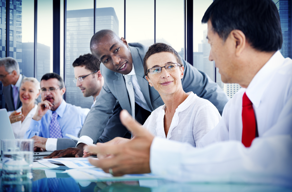 Coworkers sit in a conference room having a conversation