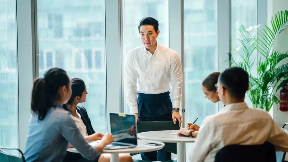 Man stands up to talk at meeting