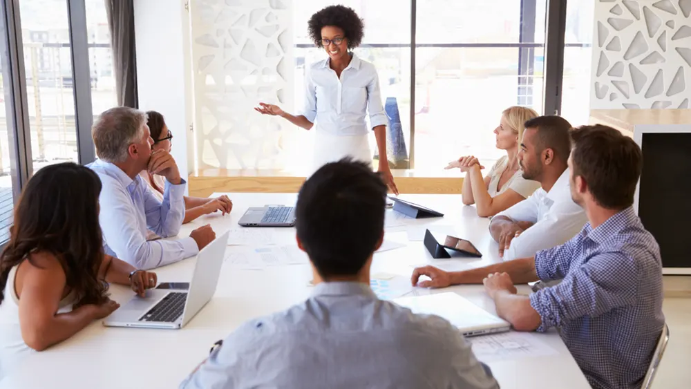 Woman stands up to talk at meeting