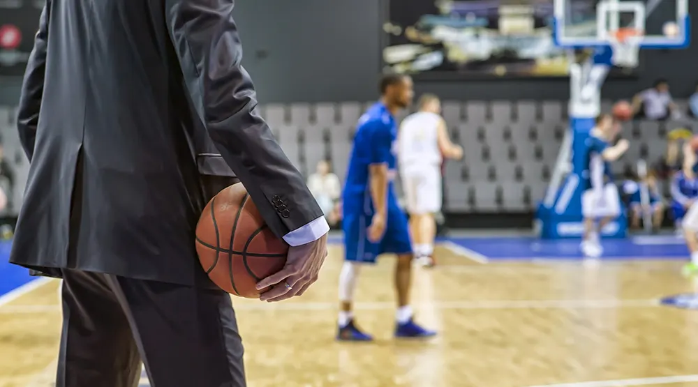 Coach watches basketball practice