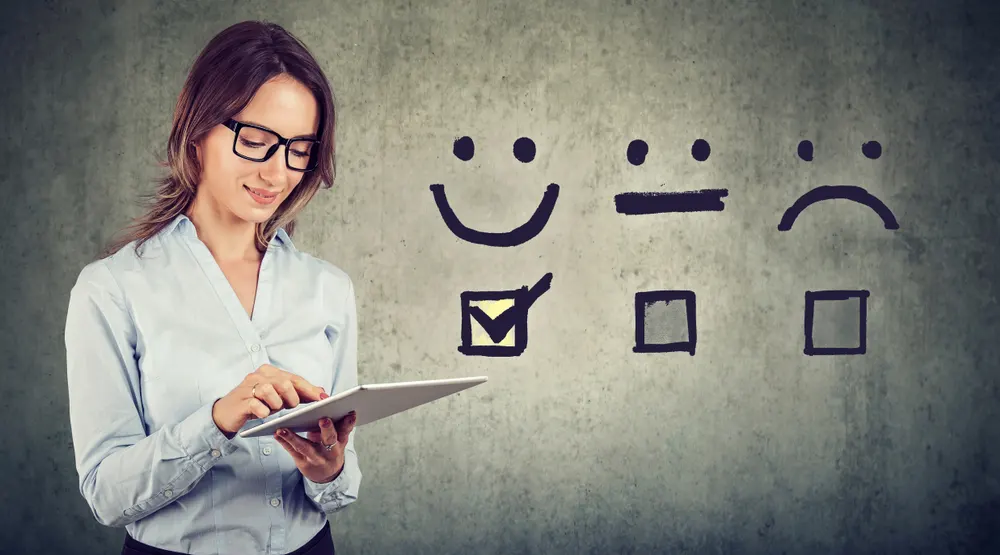 Woman choose smiley face on handheld device