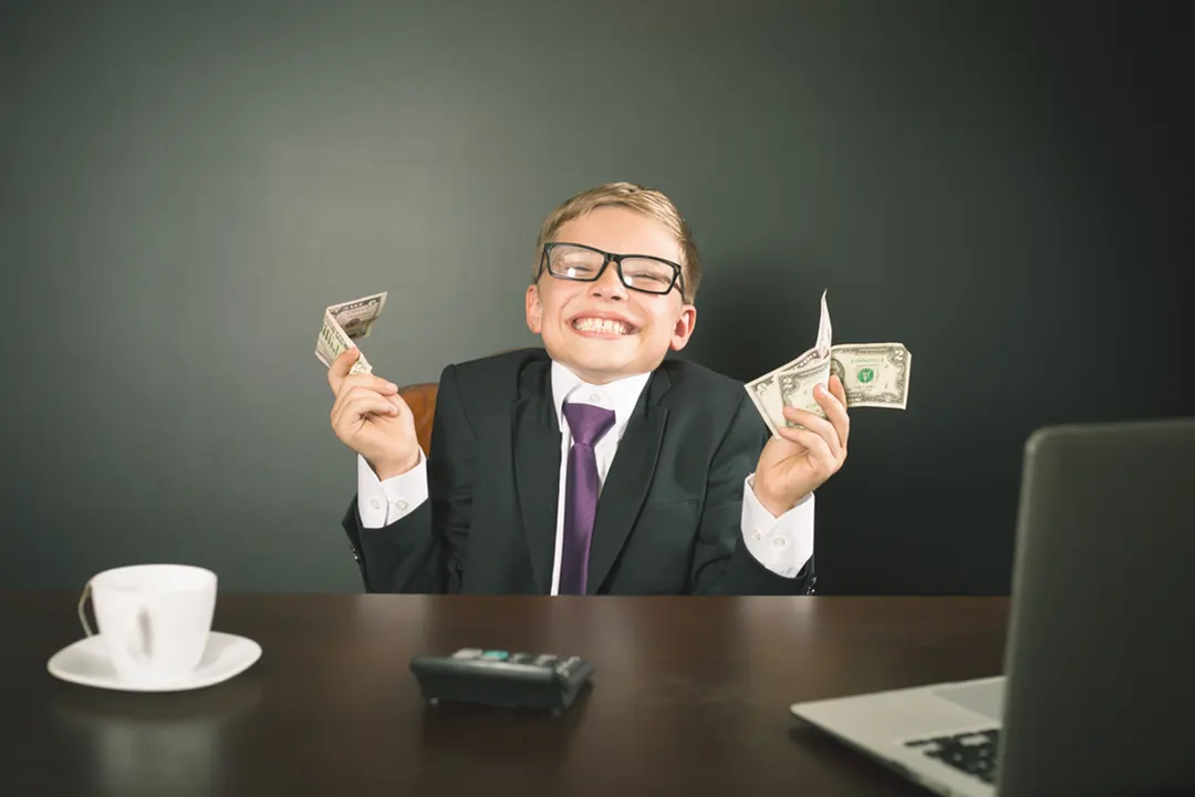 Grinning boy in suit holds cash