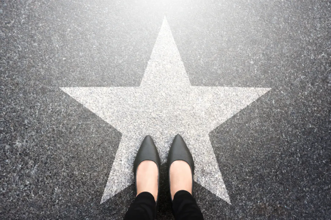 Woman stands on pavement star