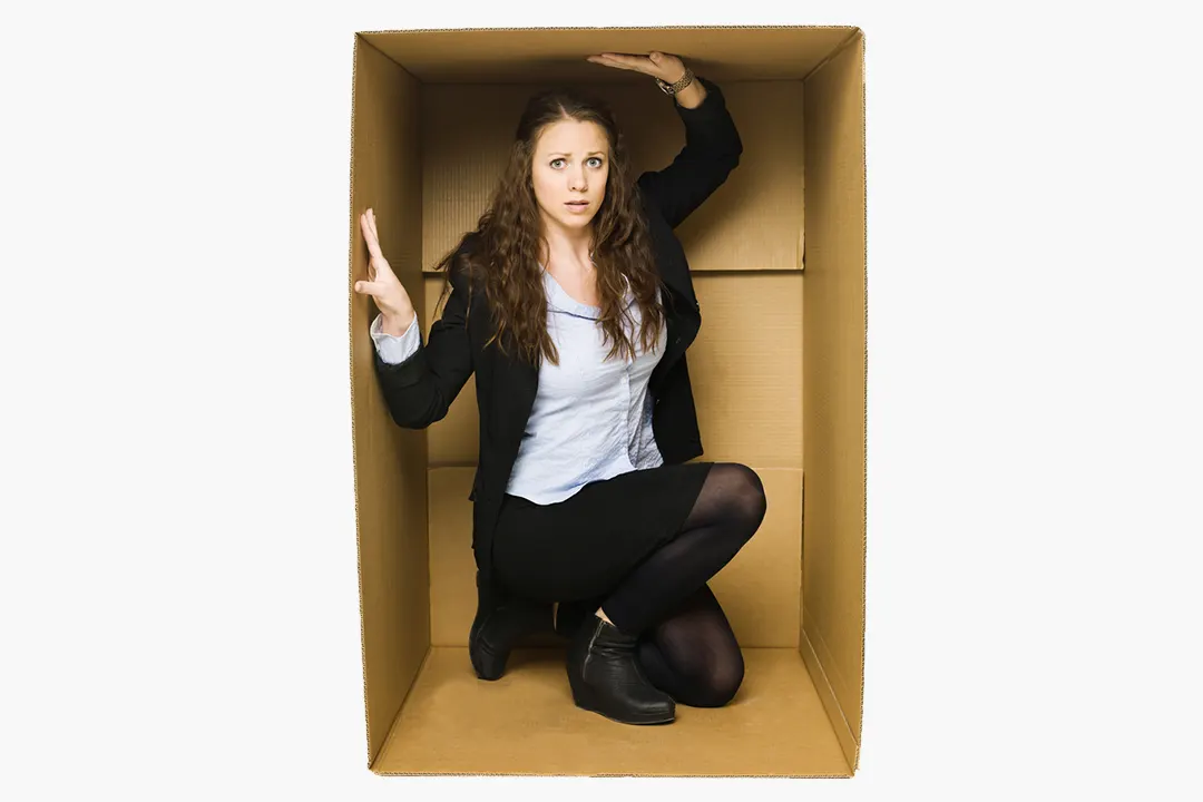 Woman crouches in box