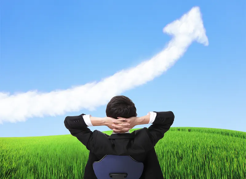 Man in field looks at cloud shaped like rising profit arrow