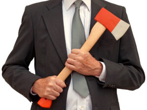 A businessman holds a red ax with a light brown handle with two hands