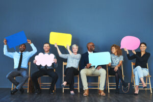 A diverse group of employees or candidates hold up speech bubbles of different colors