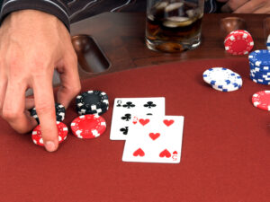 A card player moves poker chips in as he doubles down