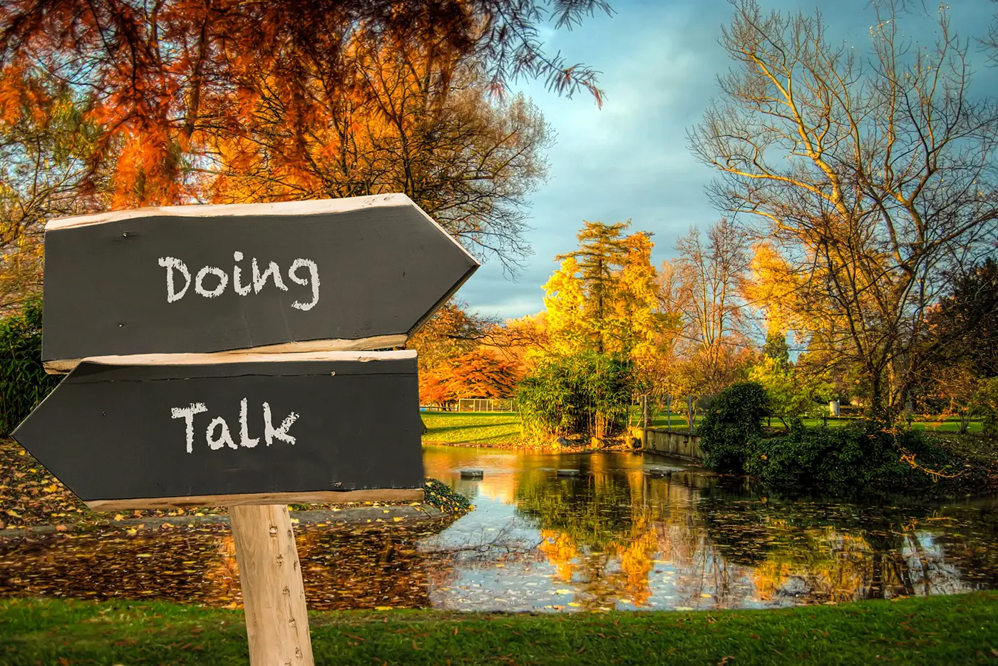 A sign that says "Doing" pointing one way and a sign that says "Talk" pointing the other way