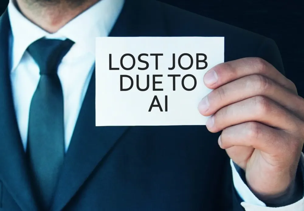 A businessman in a suit and tie holds up a sign that reads "Lost Job Due to AI"
