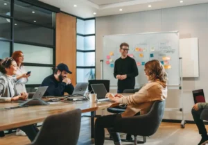 A corporate team works on a project in a meeting room, balancing competition and collaboration.