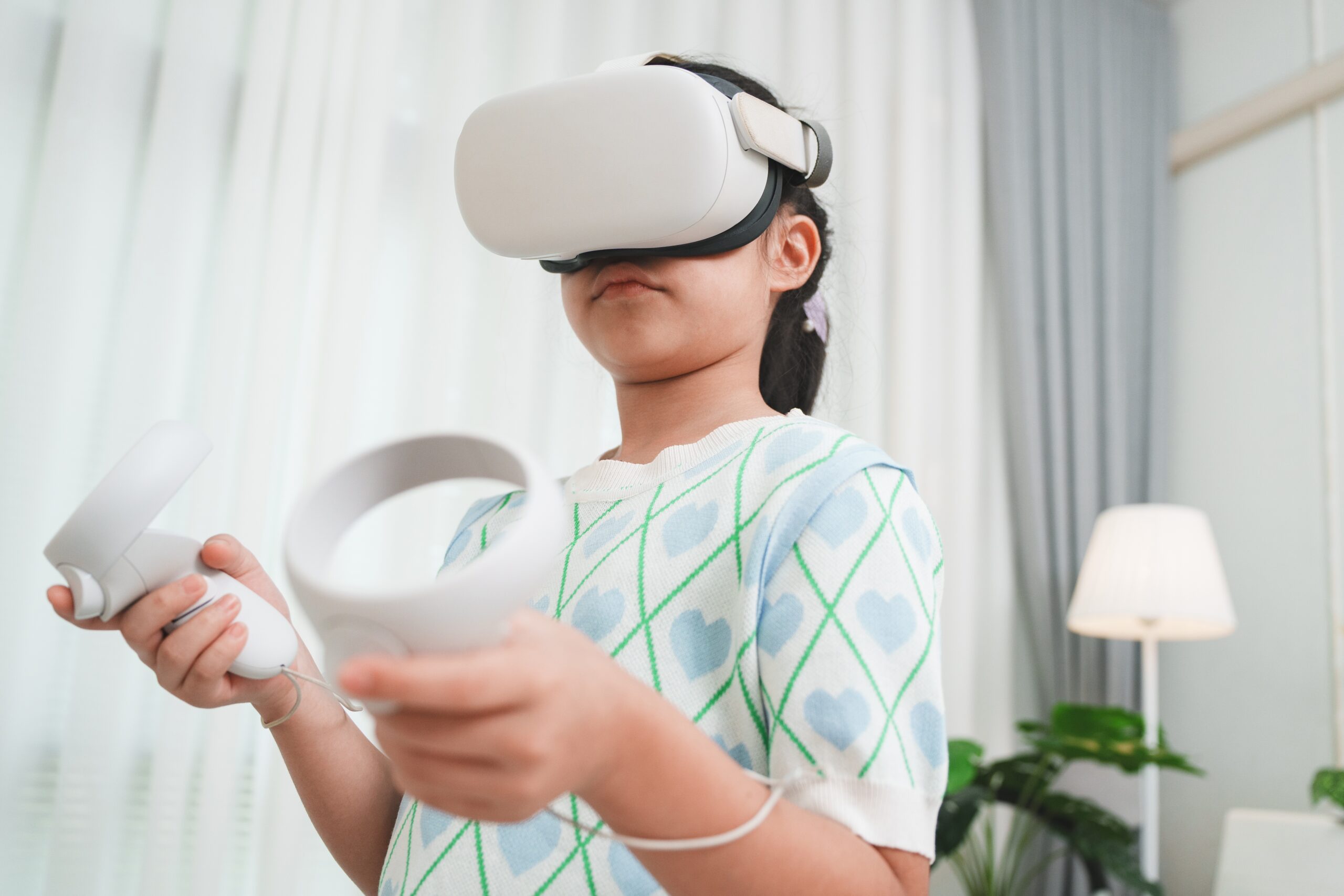 A young girl wearing a VR headset and holding controllers is a student learning from AI-powered education technology (edtech).