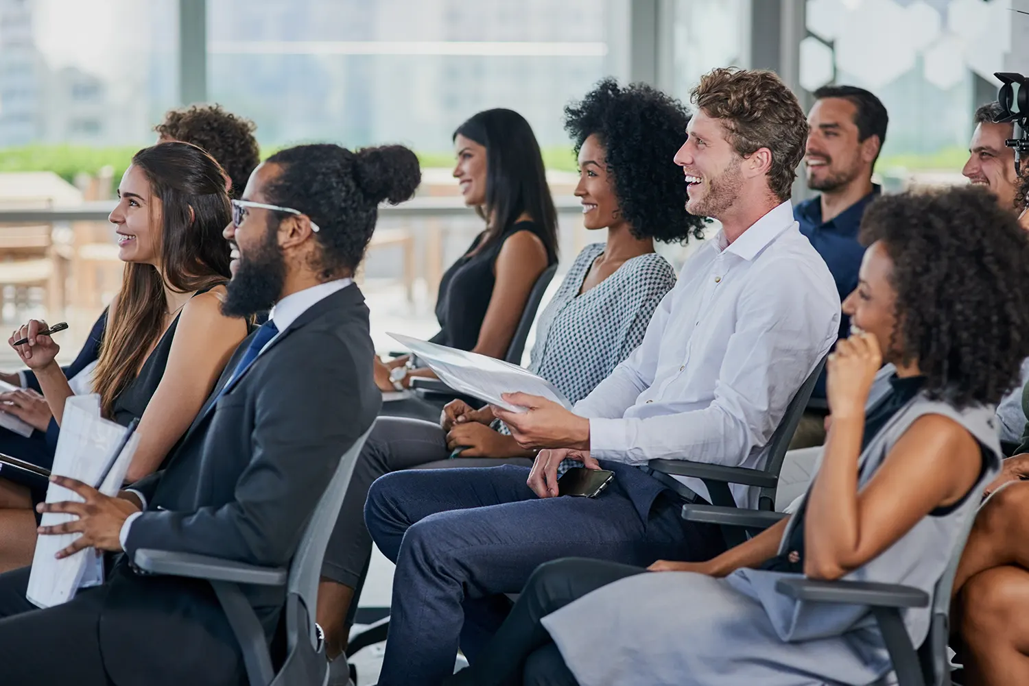 A group of employees sits in a conference room during a diversity, equity, and inclusion training.