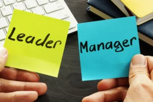 A worker holds two post-it notes, one that says 'Leader,' the other that says 'Manager'