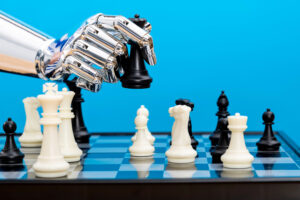 Robot hand holding chess pieces.