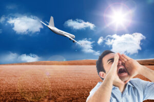 Shouting casual man standing in a brown grassy field in front of descending plane with sun and clouds in a blue sky