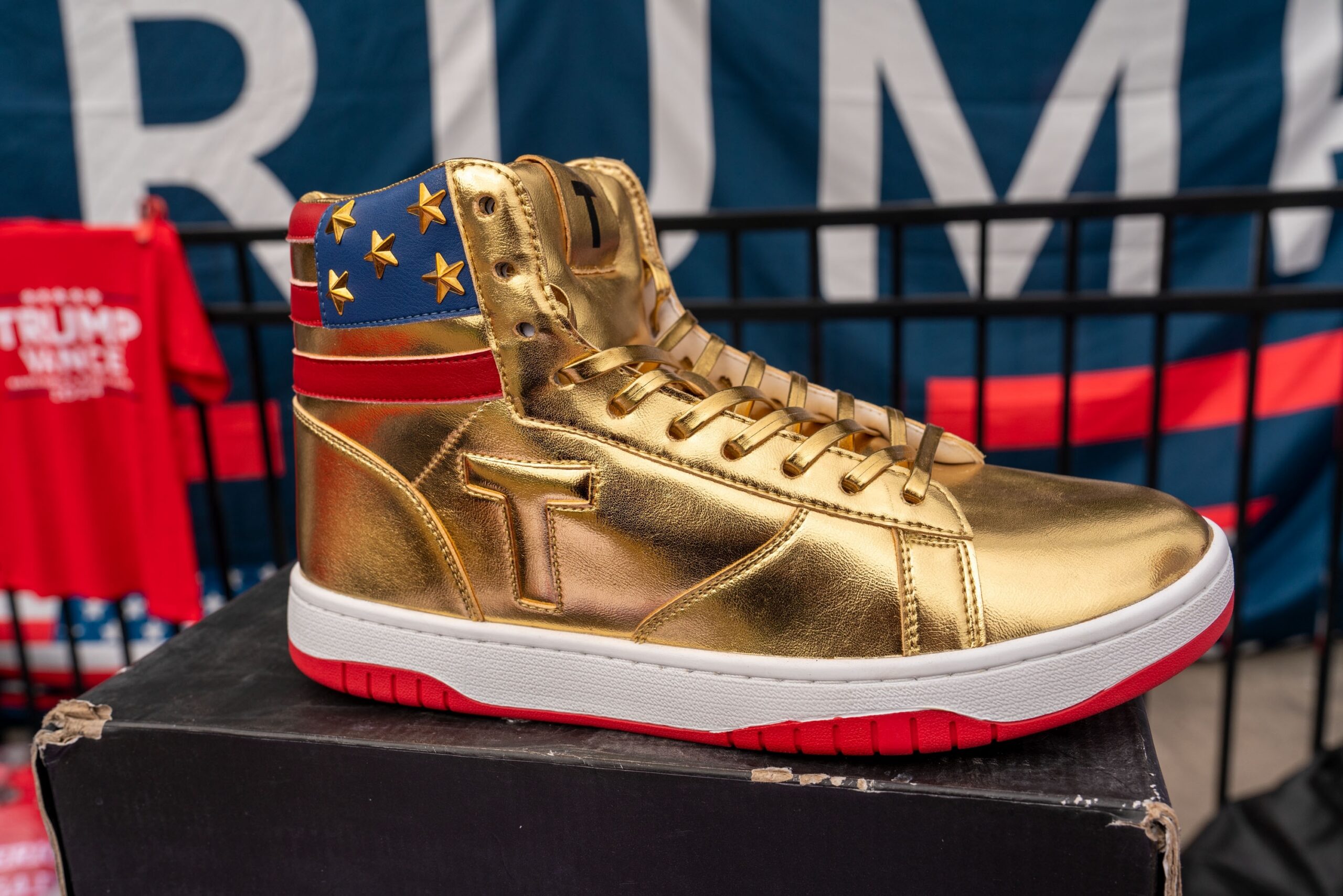 Atlanta, Georgia, USA, October 28, 2024 Vendors sell Trump election merchandise(Trump logo gold sneakers) at former President and 2024 Republican presidential nominee's rally at Georgia Tech.