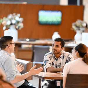 Network at events, three people sitting at a table talking