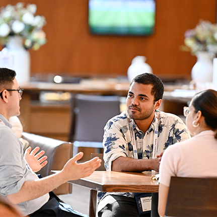 Network at events, three people sitting at a table talking