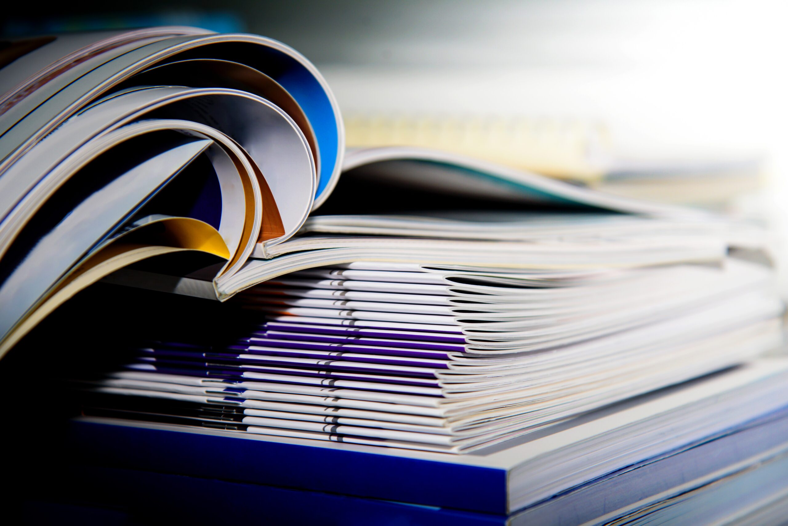 Stack of academic papers with the top few binders opened.