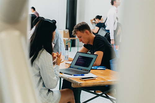 Abstract image of two people working on their computers in a public space